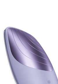 Strumento per la toelettatura di colore viola con una superficie liscia e curva, accentuata da rilievi. Presenta setole fini lungo il bordo e una forma ergonomica elegante.