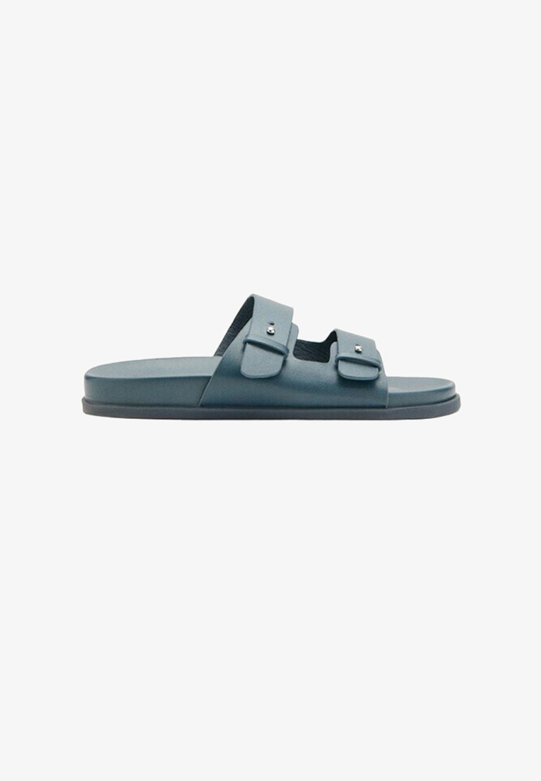 Niebieska klapka na płaskiej podeszwie z dwoma regulowanymi paskami na klamry, przedstawiona z boku na białym tle.