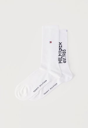 Kaks paari valgeid jalaotsaga sokke soonikkoes mansettidega, üks paaril väike punase, valge ja sinise logoga, teisel paaril tekstiga "HILFIGER est. 1985".