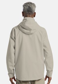 Lichtbeige waterdichte jas met een capuchon, lange mouwen en een gladde textuur. Heeft een minimalistisch ontwerp met een rechte pasvorm.