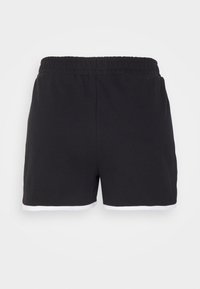 Calções atléticos pretos com um cós elástico. Apresenta acabamentos brancos ao longo da bainha inferior. Feitos de um tecido macio, concebidos para conforto.
