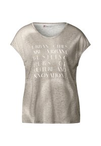 Camiseta de manga corta color beige claro con cuello en V, que presenta un patrón texturizado y texto impreso en blanco contrastante. Ajuste casual.