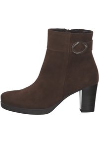 Brown suede ankle boot with a rounded toe and a  heel. Features a decorative strap with a circular metallic accent. Smooth texture.