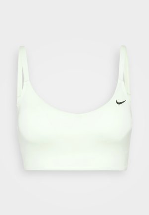 Soutien-gorge de sport blanc avec des bretelles réglables, texture lisse, bande large et un petit logo Nike noir sur le côté gauche.