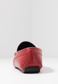 Rote Lederloafer mit abgerundetem Rücken, kontrastierenden Nähten und glatter Textur. Verfügt über eine schwarze Gummisohle für Langlebigkeit.