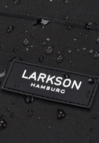 Black fabric with water droplets, featuring a rectangular black label embossed with "LARKSON HAMBURG" in white lettering.