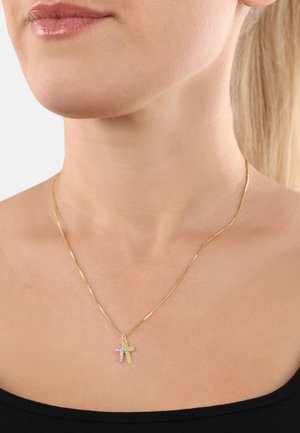 Goldkette mit einer dünnen Kette, die einen zweifarbigen Kreuzanhänger trägt; eine Seite ist goldfarben und die andere ist mit klaren Steinen verziert.