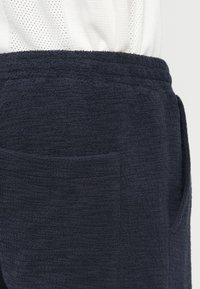 Σορτς από περκάλι σε ναυτικό μπλε με υφή, διαθέτει πλευρική τσέπη σε γωνία και ελαστική μέση για άνεση.