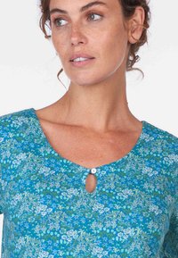 Blaues blumenmusterndes Hemd mit einem Schlüssellochausschnitt und einem Knopf, strukturiertem Stoff und lockerer Passform.