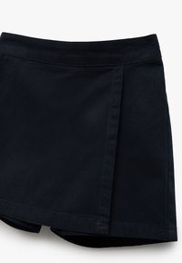 Jupe évasée noire en coton, avec une texture lisse, un détail de plis et un ourlet arrondi. Design simple sans matériel visible.