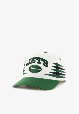 White and green baseball cap with "JETS" text and abstract green and black triangular patterns on the front and sides.