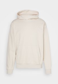 Beige hooded sweatshirt, made of soft fabric, featuring a front pocket, ribbed cuffs, and a small white logo on the chest.