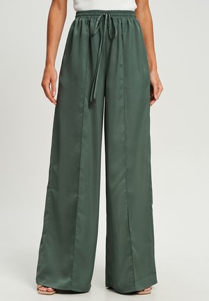 Wide-leg trousers in dark green satin fabric. Elastic waistband with drawstring. Smooth texture, flowing design, and loose fit.