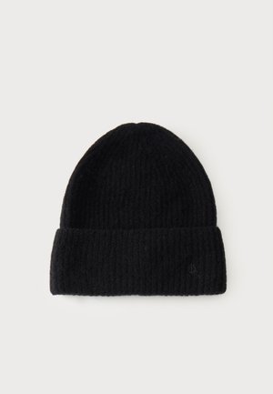Bonnet noir en tricot avec revers plié et logo discret sur le revers, présenté sur un fond clair.