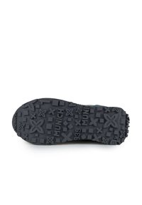 Suela de goma negra con un patrón texturizado que presenta varias formas y la palabra "MUNICH" grabada. Duradera y diseñada para ofrecer tracción.