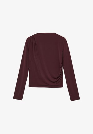 Maglietta bordeaux a maniche lunghe realizzata in tessuto morbido. Presenta un dettaglio drappeggiato sulla parte posteriore e una leggera arricciatura ai lati. Collo a giroclassico.