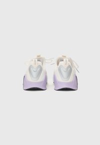 Witte en lavendel sneakers hebben een textuur bovenwerk, rubberen zool, hielaccent en reflecterende details aan de achterkant met veters.