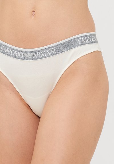 Fehér pamut tanga szürke elasztikus derékkal, rajta az "Emporio Armani" logóval. Simább textúra, minimális dizájn és standard fazon.
