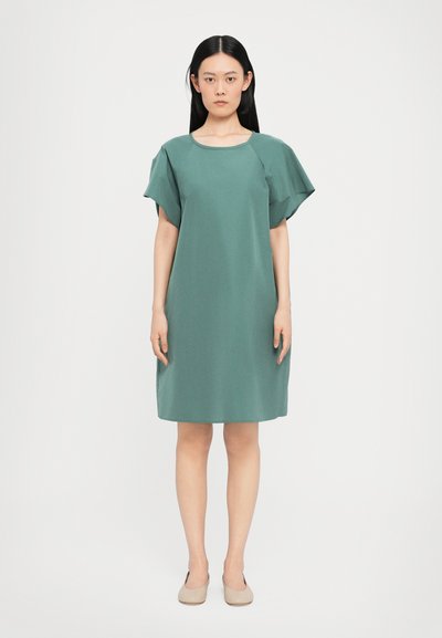 Kurzärmliges, knielanges Kleid aus einem gedämpften grünen Stoff mit rundem Ausschnitt und lockerer Passform, das seitliche Schlitze für einen besseren Bewegungsraum aufweist.