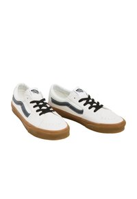 Hvide lærredssko til skateboard med sorte snørebånd og en grå side-stribe. Udstyret med en gummisål og perforeret tå for åndbarhed.