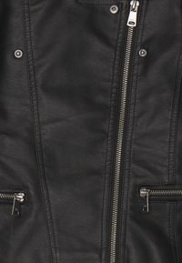 Giacca nera in similpelle con cerniere argento, dotata di due tasche con cerniera e una texture liscia. Dettagli cuciti lungo le cuciture.