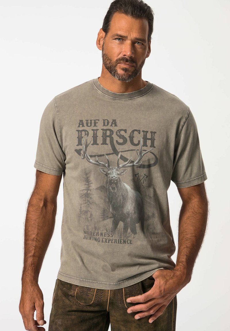 Camiseta de algodón gris con un gráfico en el frente de un ciervo, texto "A uf da Pirsch" y detalles de un paisaje rústico. Mangas cortas, cuello redondo.