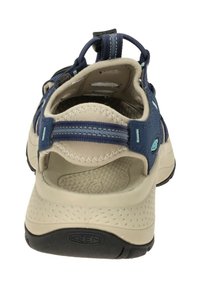 Navy blue sandal with a breathable mesh upper, beige rubber sole, back pull tab, and textured insole. Adjustable straps for secure fit.