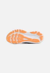 Shoe outsole featuring a textured orange rubber pattern with white midsole. Designed for traction and stability during movement.
