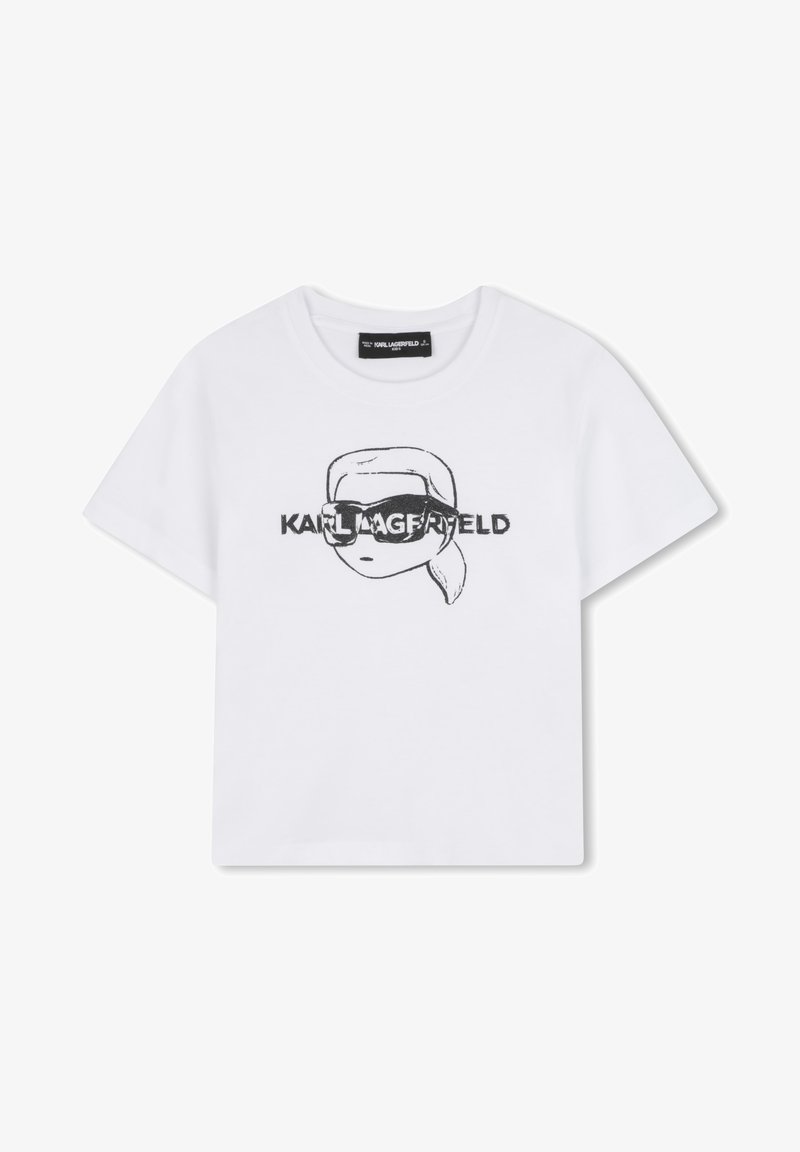 T-shirt en coton blanc avec un graphique noir représentant un personnage portant des lunettes de soleil et le texte "KARL LAGERFELD", col rond, manches courtes.