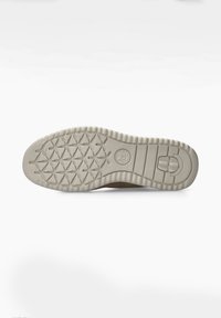 Semelle de chaussure en caoutchouc beige avec un motif de grip texturé, présentant un logo rond et des bords surélevés pour la stabilité et l'adhérence.