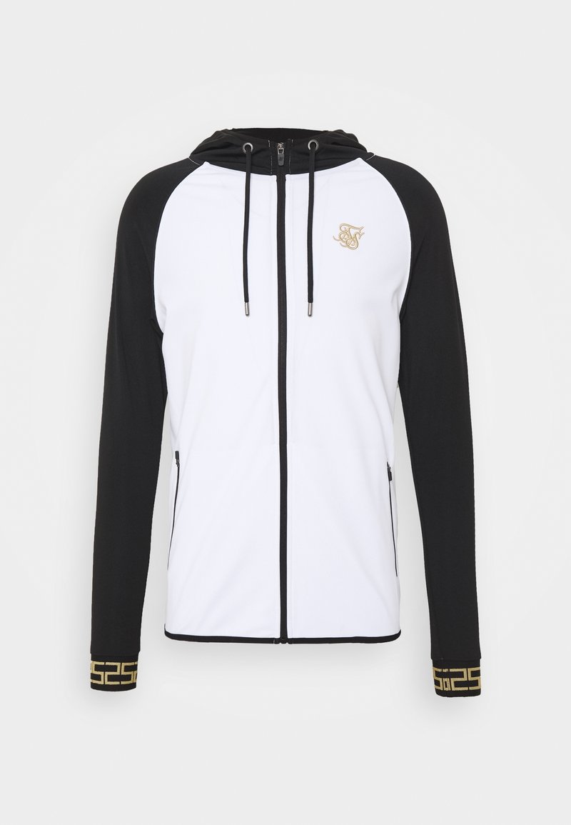 Veste à capuche zippée avec des manches noires et un corps blanc. Détail du logo doré et poignets à motif. Fabriquée en tissu lisse et léger.
