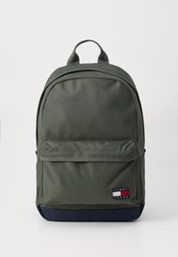 Olive green backpack made of textured fabric, featuring a front pocket, reinforced top handle, and navy blue bottom. Logo displayed prominently.
