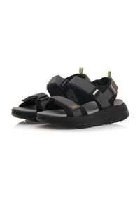 Sandali neri e grigi con cinturini regolabili, materiale sintetico, soletta imbottita, suola texturizzata e anello verde accentato sul tallone.