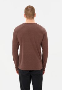 Bruine lange mouwen shirt van zachte stof, met een ronde halslijn en een licht gebogen zoom. Minimalistisch ontwerp zonder zichtbare patronen.