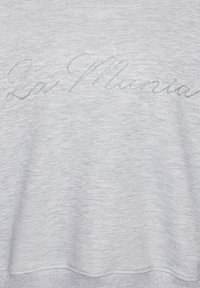 Țesătură gri deschis cu broderie subtilă în relief a inscripției „La Marina” în stil cursiv, pe centru.