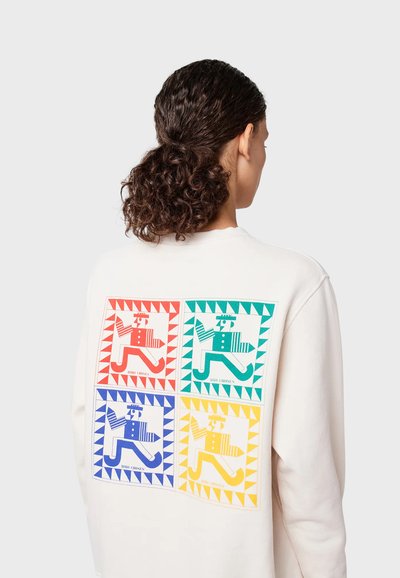 Felpa crema con una grafica sulla parte posteriore che presenta quattro quadrati colorati, ognuno dei quali ritrae una figura giocosa in rosso, verde, blu e giallo.