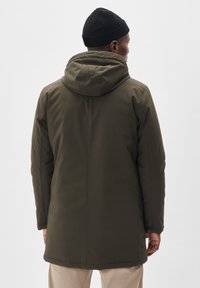 Olivgrüner, wasserdichter Parka mit Kapuze, langen Ärmeln und gerader Schnittform. Verfügt über eine glatte Textur und einen leichten Glanz.