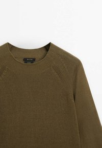 Pull tricoté vert olive avec un col rond, des manches raglan et un motif texturé. Étiquette visible au niveau du col.