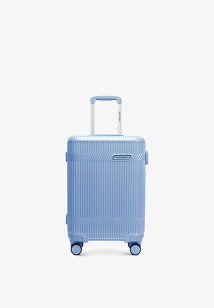 Valise rigide bleu clair avec rainures verticales, poignée télescopique, quatre roues pivotantes et logo "Wittchen" sur le devant.