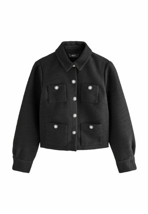 Veste noire texturée avec un col, fermeture à boutons argentés à l'avant et deux poches poitrine. Présente des manches longues et une coupe courte.