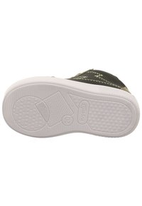 Schwarze Schuhsohle mit weißer Gummiaußensohle, die über strukturierte Muster und geprägte Markenlogos verfügt. Entwickelt für Traktion und Stabilität.