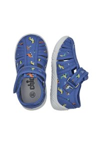 Modré textilní sandály s motivem dinosaurů, vybavené suchým zipem a bílou gumovou podrážkou. Otevřený design pro prodyšnost.