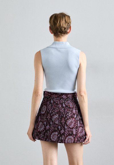 Light blue sleeveless top with a collar paired with a burgundy patterned mini skirt featuring floral and paisley designs.