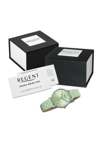 Montre vert menthe avec un bracelet en silicone texturé, boîtier en acier inoxydable et cadran vert clair. Comprend des boîtes-cadeaux noires et une carte de garantie.