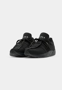 Black athletic shoes with a sleek design, made from breathable fabric. Features laces, a padded collar, and textured outsole for grip.