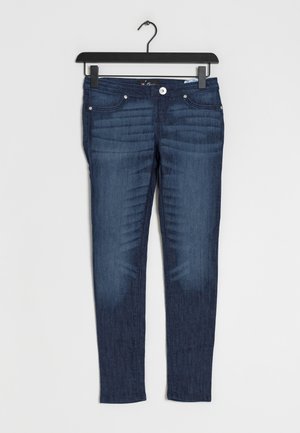 Tight passform, mörkblå denimjeans med fem fickor, dragkedja och knäppning. Har subtila vissningar och sömdetaljer.