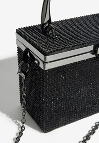 Černé obdélníkové psaníčko s texturovaným povrchem, stříbrným lemováním, řetízkovým popruhem a horním držadlem na bílém pozadí.