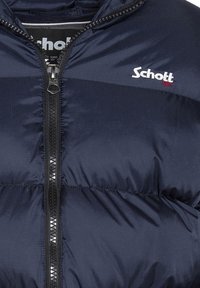 Chaqueta acolchada de color azul marino con cremallera frontal y detalle del logo. Cuenta con una tela texturizada, costuras visibles y un alto cuello.