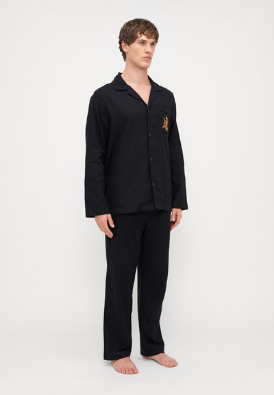 Set de pijama negru, compus dintr-o cămașă cu nasturi, care are un buzunar pe piept și detalii brodate, asortată cu pantaloni drepti care se potrivesc.