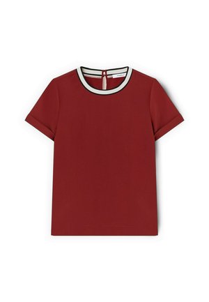 Haut rouge à manches courtes avec un col rond, doté d'une bordure blanche et noire. Détail en forme de clé à l'arrière ajoutant un accent fonctionnel. Texture de tissu lisse.